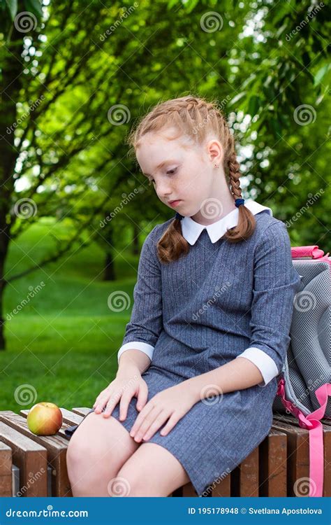 Red Haired Girl Sits On A Bench And Is Sad Pupil Student In School