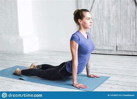 Young Woman Practicing Yoga Indoors On Blue Fitness Mat Stock Photo