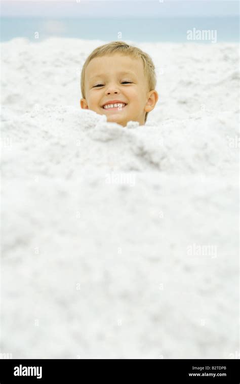 Boys Head Emerging From Sand Smiling At Camera Stock Photo Alamy