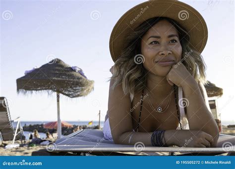 Beautiful Vietnamese Asian Woman Relaxing On The Beach Bed Facing The