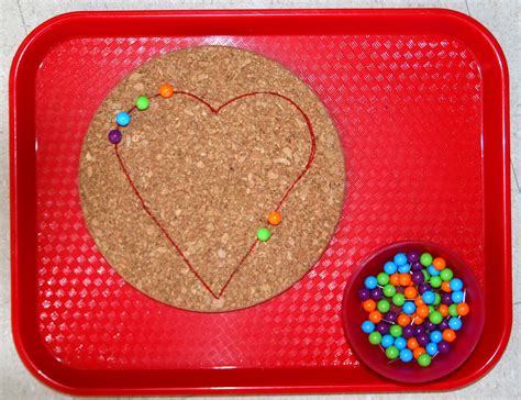 Children Use The Colored Pins To Trace The Heart On The Cork Which