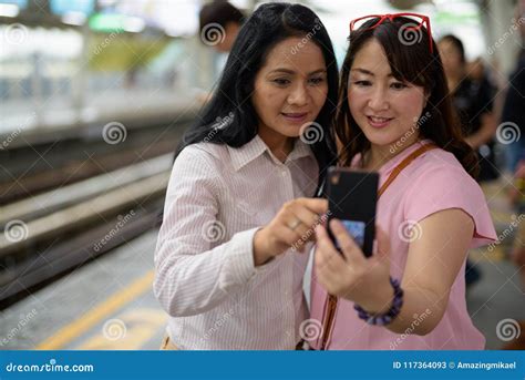 dos mujeres asiáticas maduras junto en la estación del skytrain en bangk imagen de archivo