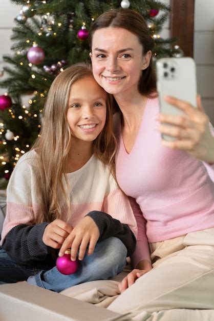 Madre E Hija Tomando Un Selfie Junto Al árbol De Navidad Foto Gratis