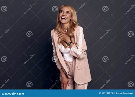 happy and carefree emotive blond alluring woman having fun laughing out loud from joy and