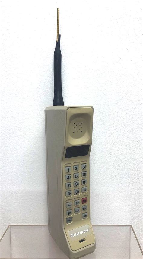 An Old Style Phone Sitting On Top Of A Clear Shelf With A Black Cord