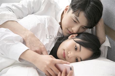 couples play cell phones in bed picture and hd photos free download on lovepik