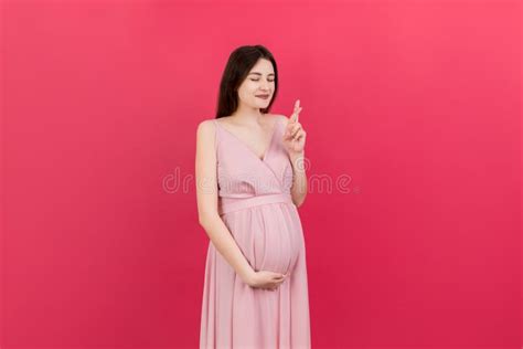 Alegre Joven Embarazada Con Los Dedos Cruzados Esperando Embarazo Aislado Sobre Fondo De Color