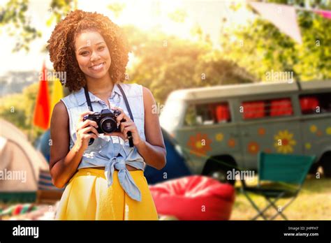 Smiling Girl Holding A Camera Against Empty Campsite At Music Festival