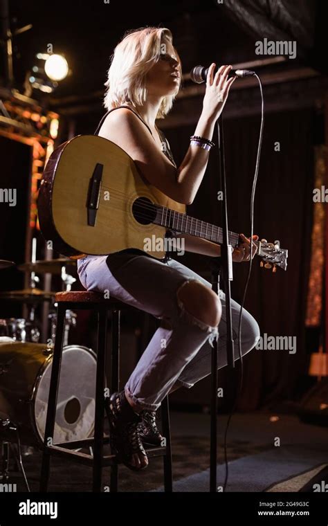 Performer Singing While Holding Guitar At Nightclub Stock Photo Alamy