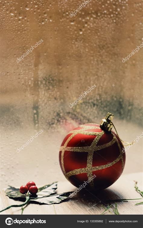 Holly And Christmas Ball In A Rainy Day — Stock Photo © Nito103 133355892