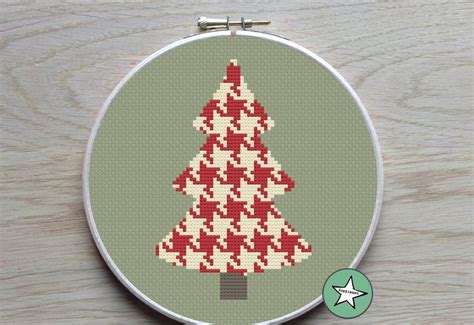 a cross stitch christmas tree on a green background
