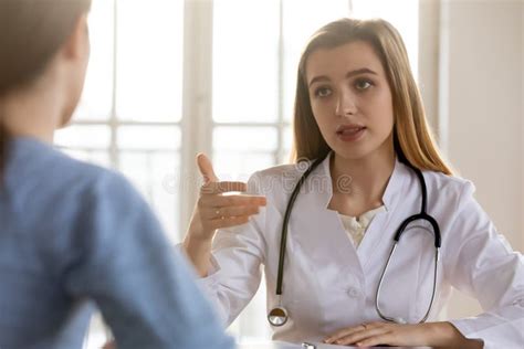 Serious Female Doctor Consulting Patient At Medical Appointment In
