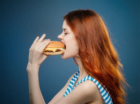 Premium Photo Young Woman Eating A Juicy Burger Delicious Fast Food Hamburger