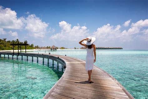 Attractive Woman Walks On A Wooden Jetty In The Maldives Stock Image