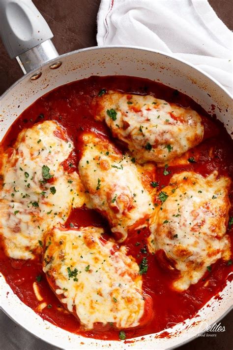 Chicken Parmesan In A White Pot With Sauce And Herbs On The Side Ready