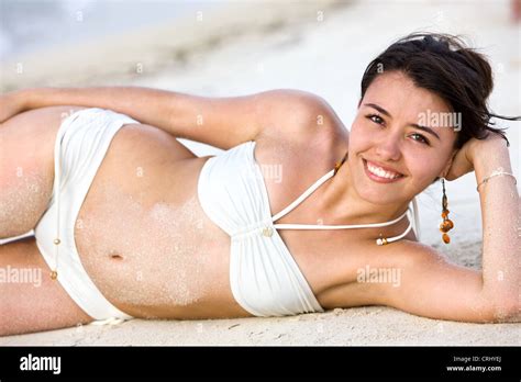 glückliche junge Frau im Bikini am Strand liegen lächelnd