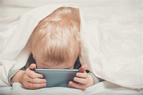 Premium Photo Little Blond Boy Buried His Nose In His Smartphone