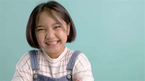 slow motion happy asian girl smiling and laughing in front of green screen stock video footage