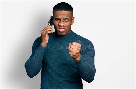Young Black Man Having Conversation Talking On The Smartphone Annoyed