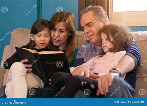 Familia Leyendo La Biblia Juntos Foto De Archivo Imagen De