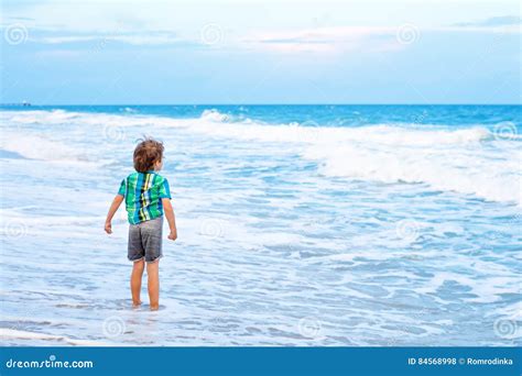 Little Kid Boy Looking On Sunset On The Beach Of Ocean Stock Photo