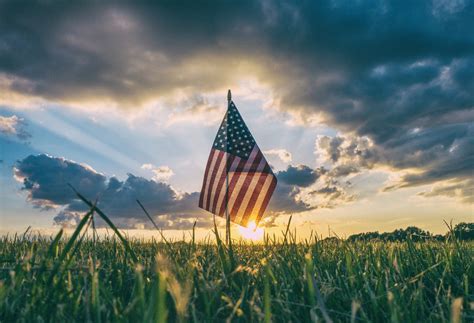 free photo american flag on the field against sunset