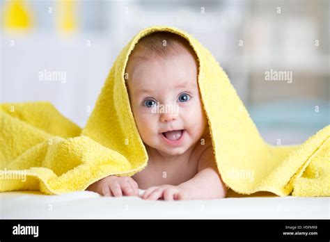 Baby Girl Covered With A Bath Towel Lying On Tummy In The Bathroom