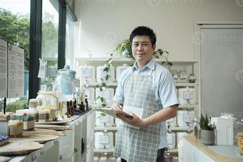 Portrait Of An Asian Male Shopkeeper Smiling And Looking At Camera
