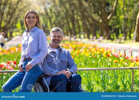 Woman And Disabled Man In Wheelchair Walking In Park Romantic Walking