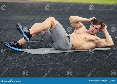Fitness Man Doing Sit Ups In The Stadium Working Out Muscular Male
