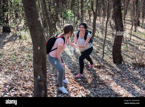 Two Happy Female Friends Hiking In The Forest Stock Photo Alamy