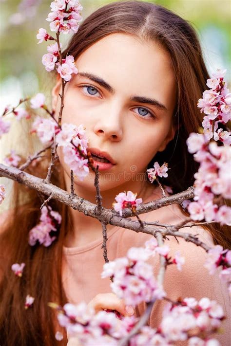 Young Girl Posing Near Blossom Cherry Tree With Pink Flowers Stock