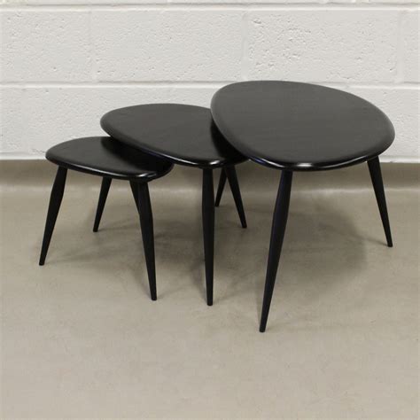 Pebble is a voluminous drum coffee table made of mild steel, featuring a dark antique brass finish. A nest of original 1960's Ercol pebble side tables ...