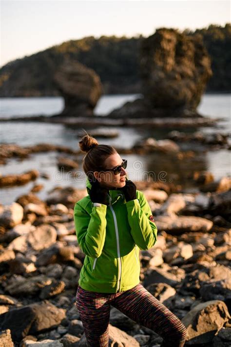 View Of Handsome Young Woman Standing On The Rocky Coast Of The Sea