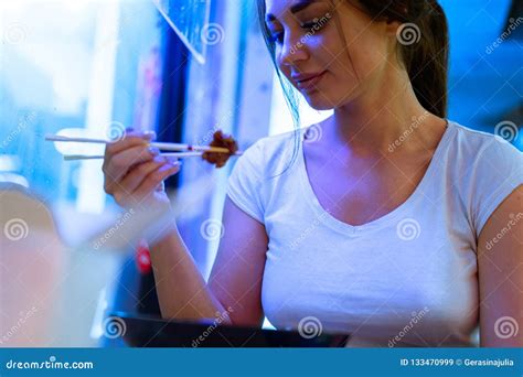 Close Up Of Attractive Woman Eating Asian Food With Chopsticks At Restaurant Stock Image