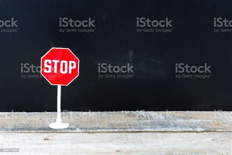 Mini Stop Sign Over Chalkboard Background And Table Stock Photo
