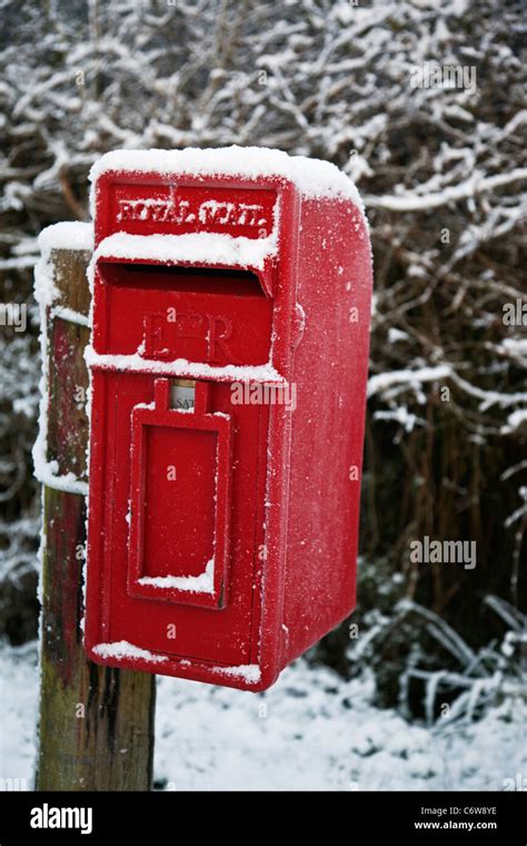 Red British Post Box On A Country Lane In Wiltshire In The Snow Stock