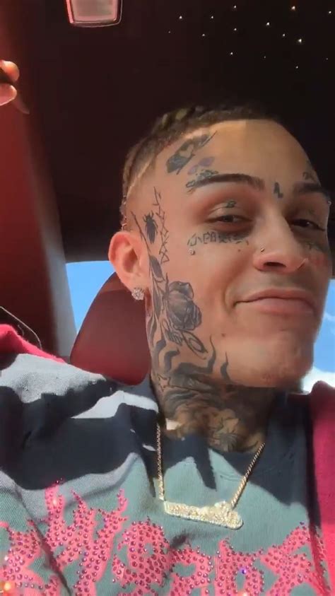 A Man With Tattoos On His Face And Neck Sitting In The Back Seat Of A Car
