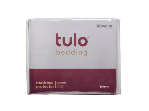The Bedding Sheets Are White And Red With Brown Lettering On Each Side