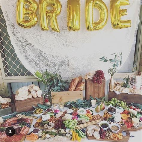 a table topped with lots of food and balloons that spell out the word