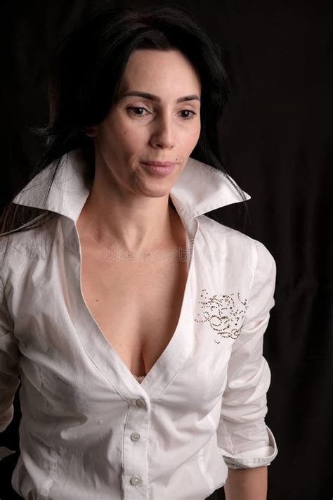 Portrait Of Beautiful Mature Brunette Woman Dressed In White Shirt Isolated On Black Background