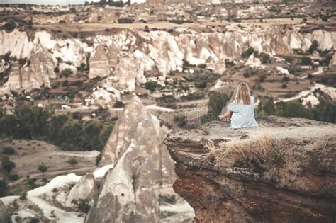 Girl Sitting On The Top Of Mountain In Cappadocia Turkey Aerial View