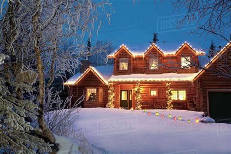 Log Home Decorated With Christmas Lights And Luminaries On The Walkway