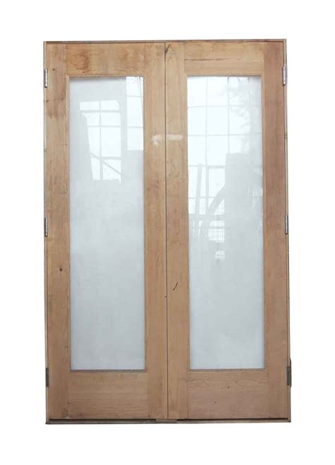 Pair Of Light Wood Tone Doors With Glass Panels In Frame