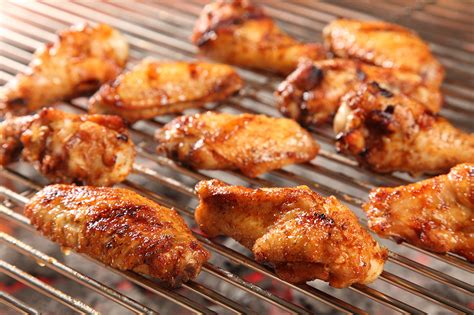 Add the wings and the water into the slow cookers and stir to coat. » Honey-Smoked-Chicken-Wings-on-Grill_web
