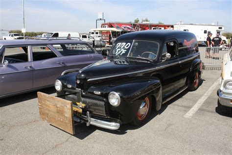 An Old Black Car Parked In A Parking Lot Next To Other Antique Cars And