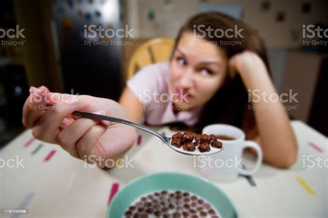 A Young Woman Shows A Spoon With Chocolate Balls And Expresses A