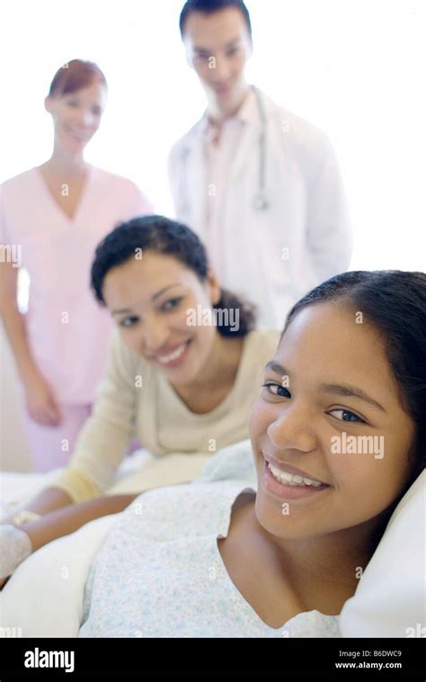 Teenage Hospital Patient Doctor And Nurse Standing By A Patient And