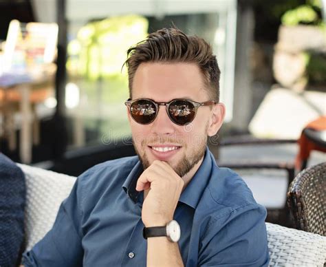 Young Handsome Man Wearing Sunglasses And Blue Shirt Smiling Stock