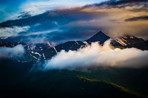 Cumulus Clouds Over Mountain Peak · Free Stock Photo